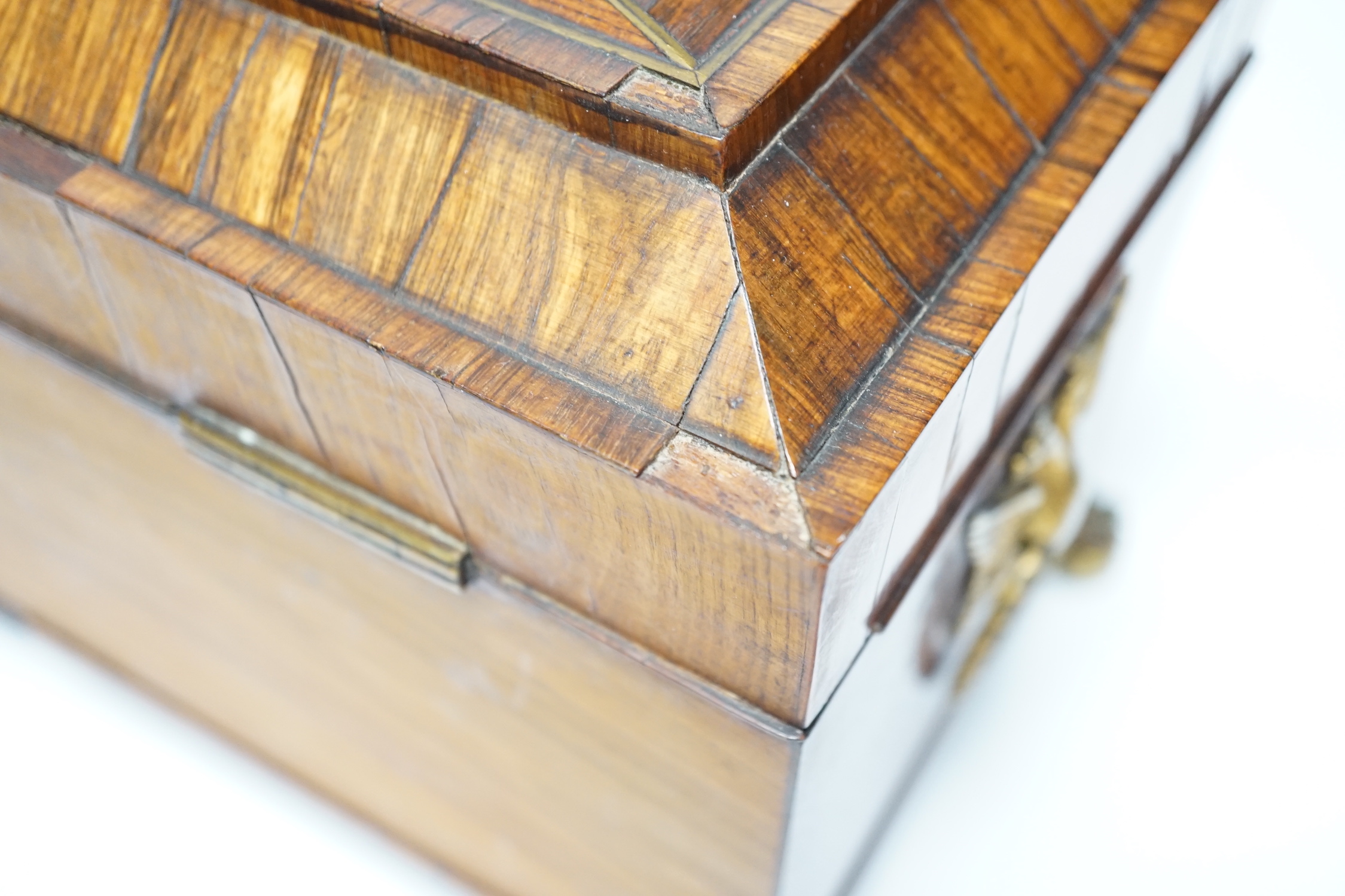A Regency kingwood and brass strung sarcophagus tea caddy, manufacturers label for Staudenmeyer, 30 Cockspur Street, Charing Cross, London, double headed eagle handles, 21.5cm high, 30.5cm wide, 15cm deep